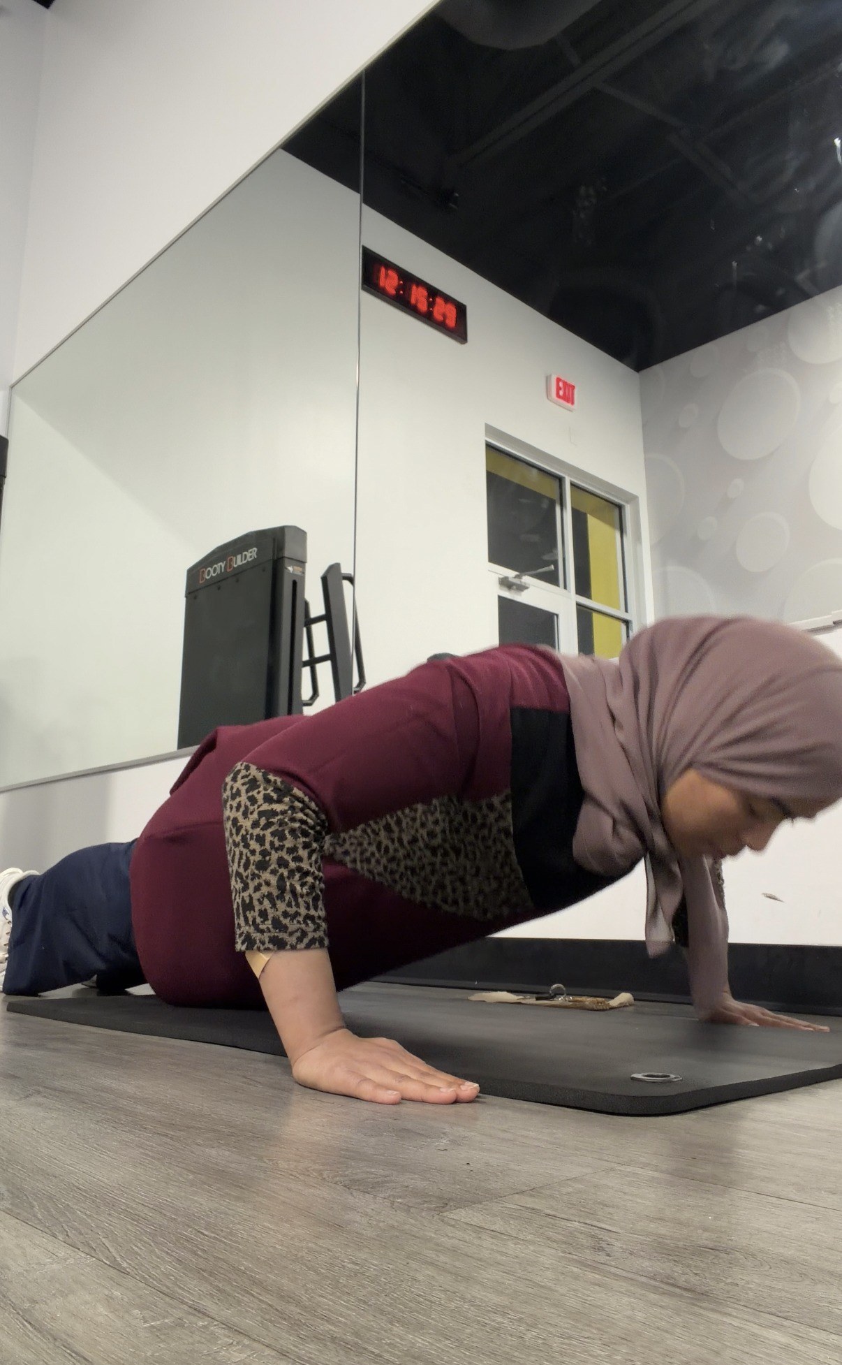 Coach Assia holding a push-up position on a mat during a training session